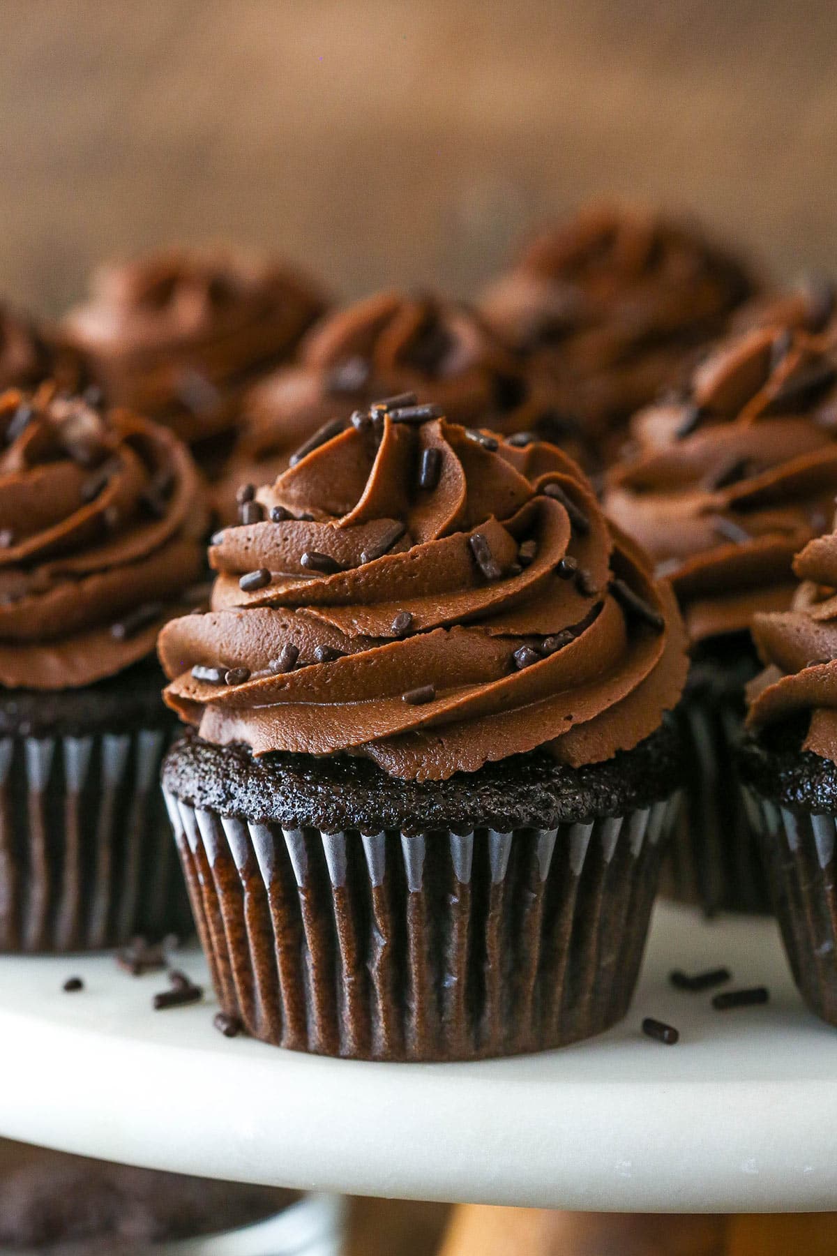 Moist chocolate cupcakes on a cake stand.