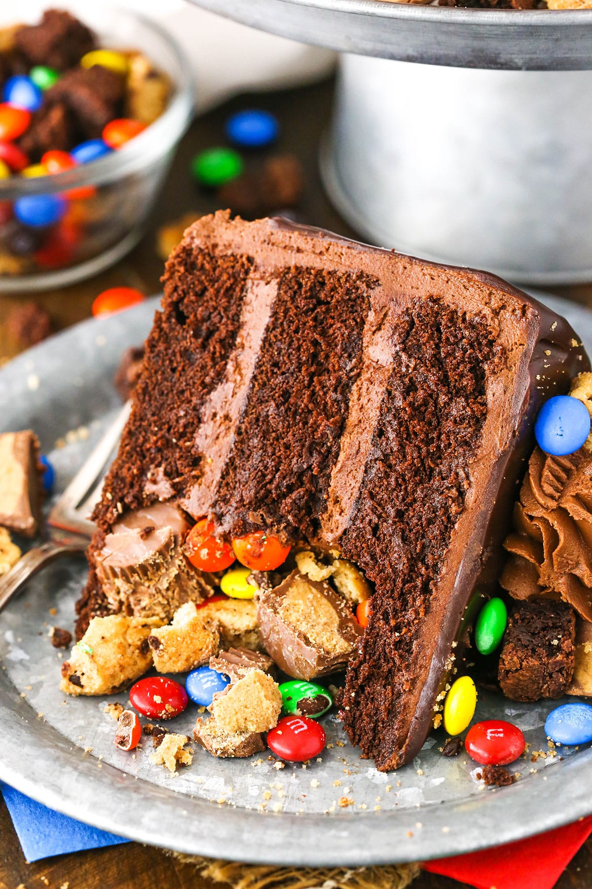 A slice of Chocolate Piñata Cake next to a fork on a gray plate