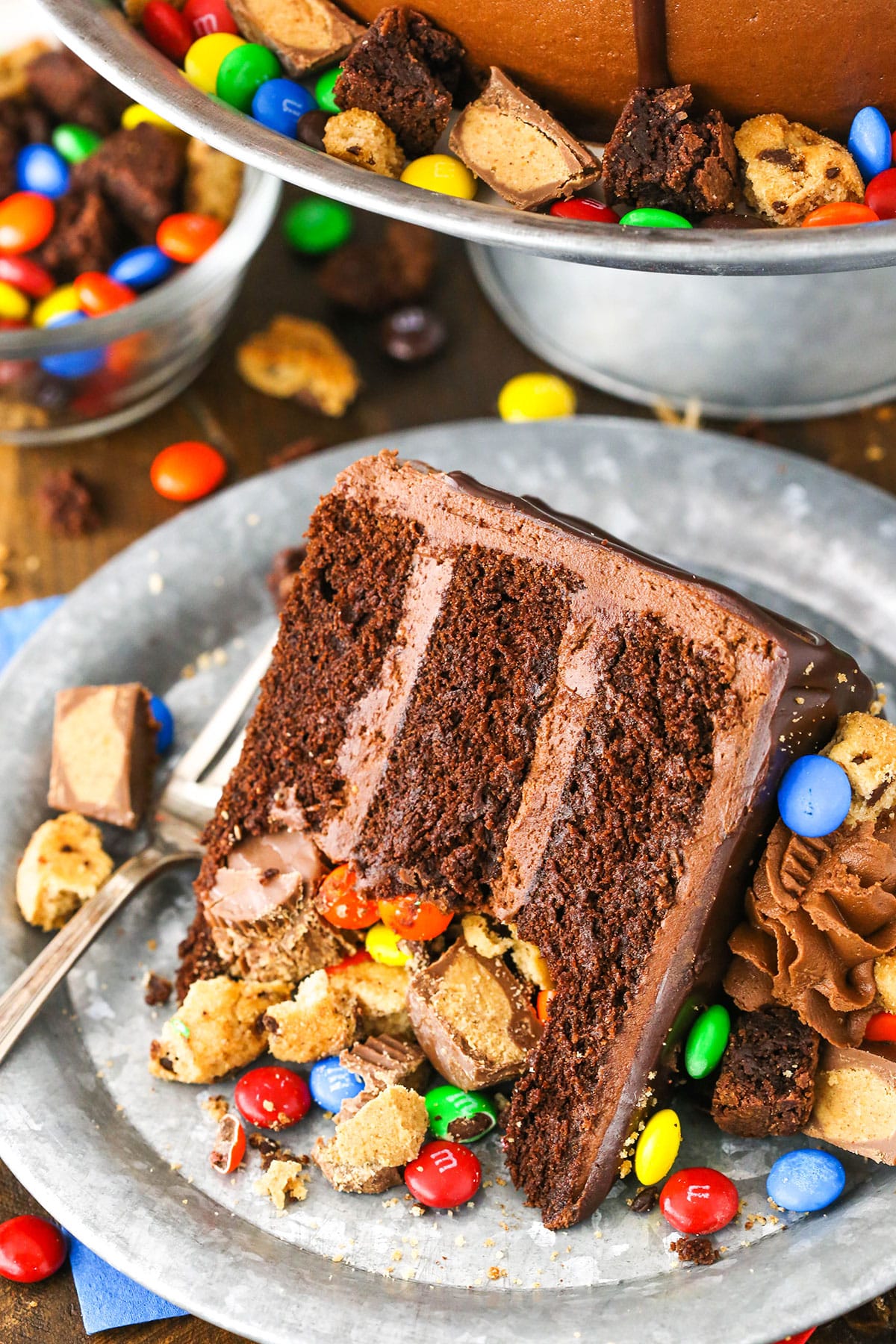 A slice of Chocolate Piñata Cake next to a fork on a gray plate