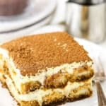 A square serving of Easy Tiramisu next to a fork on a small white plate
