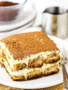 A square serving of Easy Tiramisu next to a fork on a small white plate