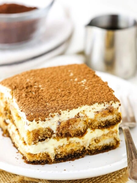 A square serving of Easy Tiramisu next to a fork on a small white plate