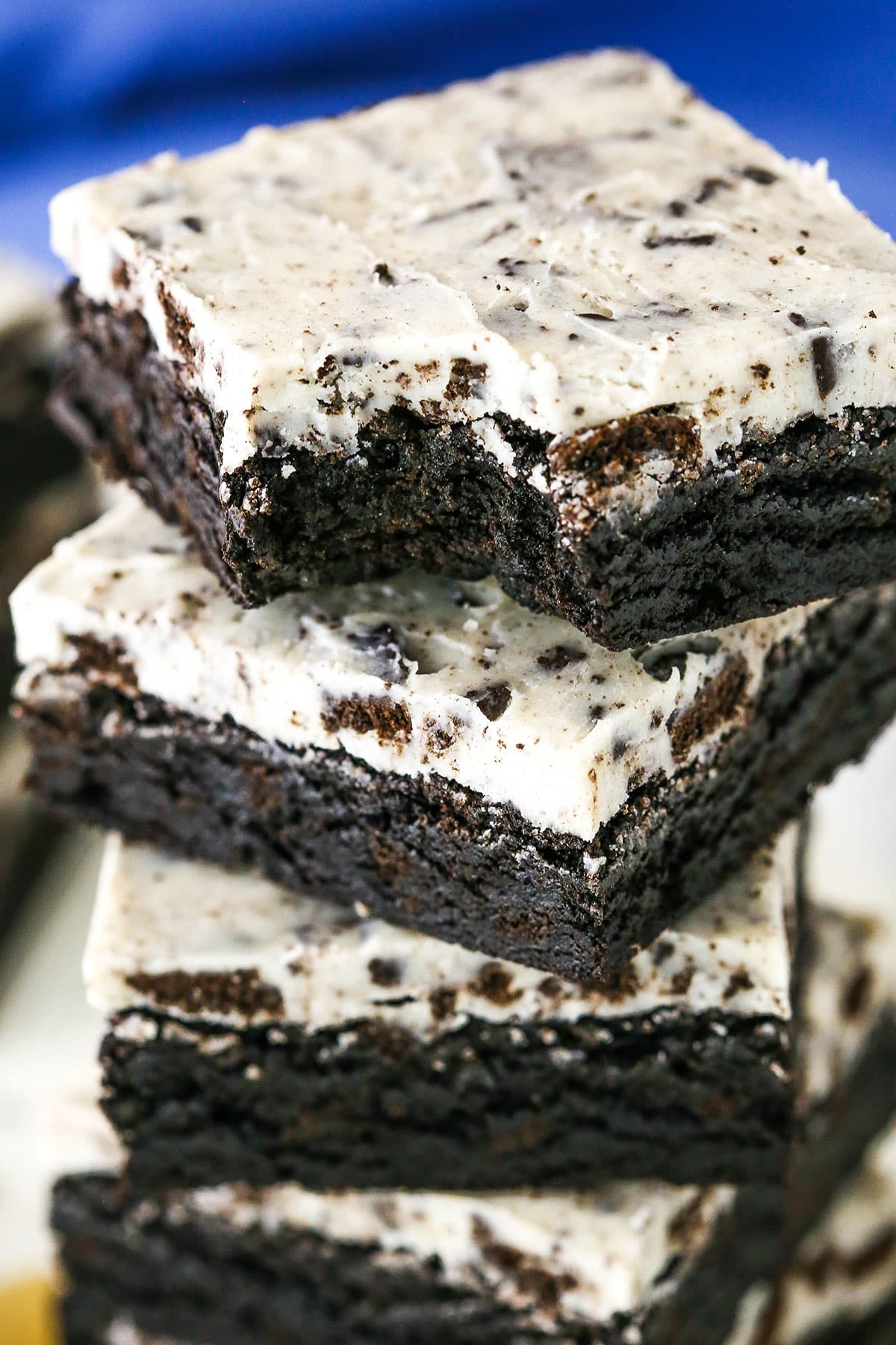 These Cookies and Cream Brownies are a fudgy brownie topped with an Oreo-filled white chocolate topping! Five Fudgy Cookies and Cream Brownies stacked on top of each other with the top brownie missing a bite