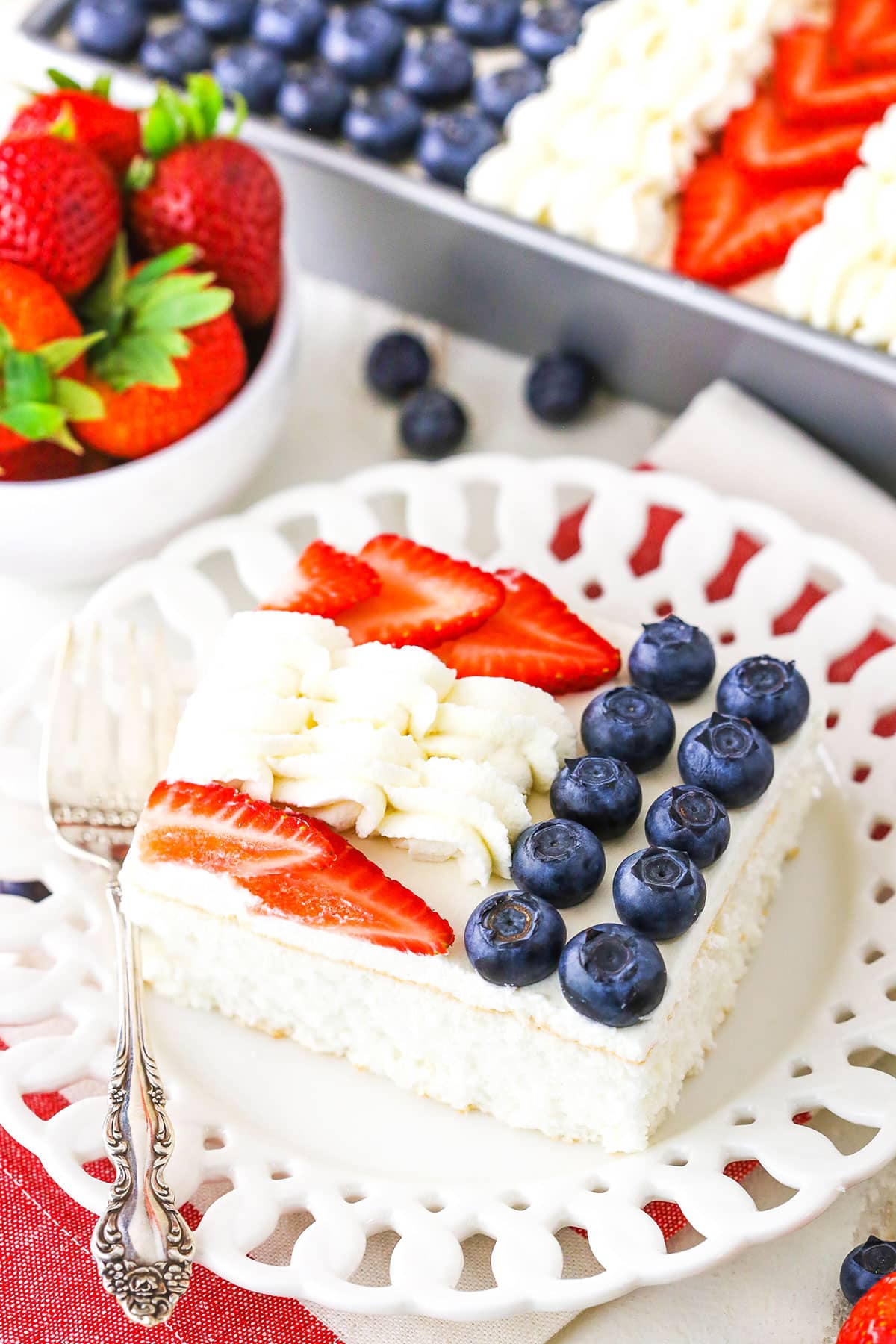 A serving of Angel Food Flag Cake next to a fork on a white plate