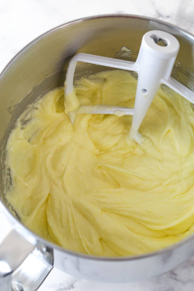 Adding eggs to the wet ingredients for cake batter.