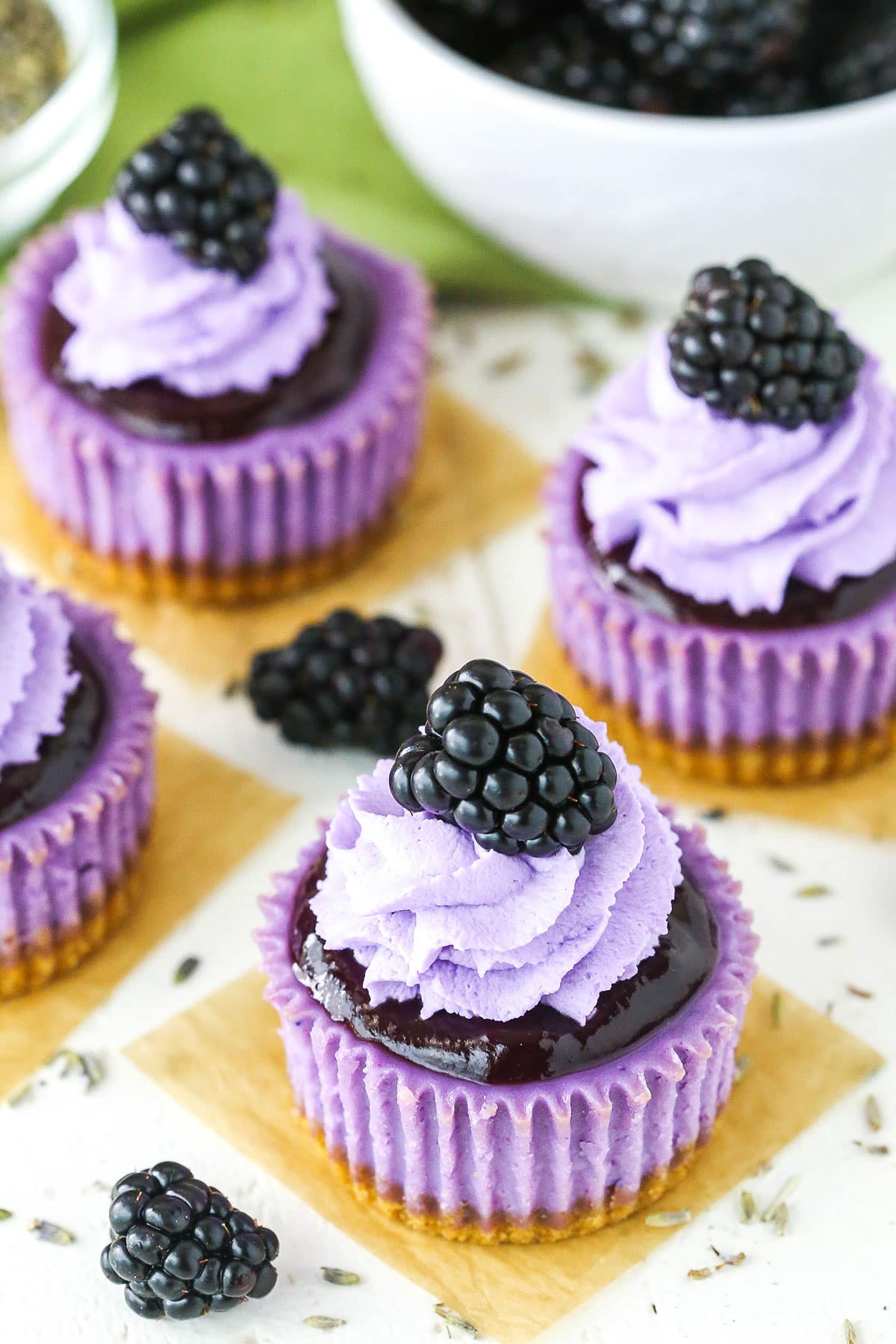 Mini Blackberry Lavender Cheesecakes on a white table top