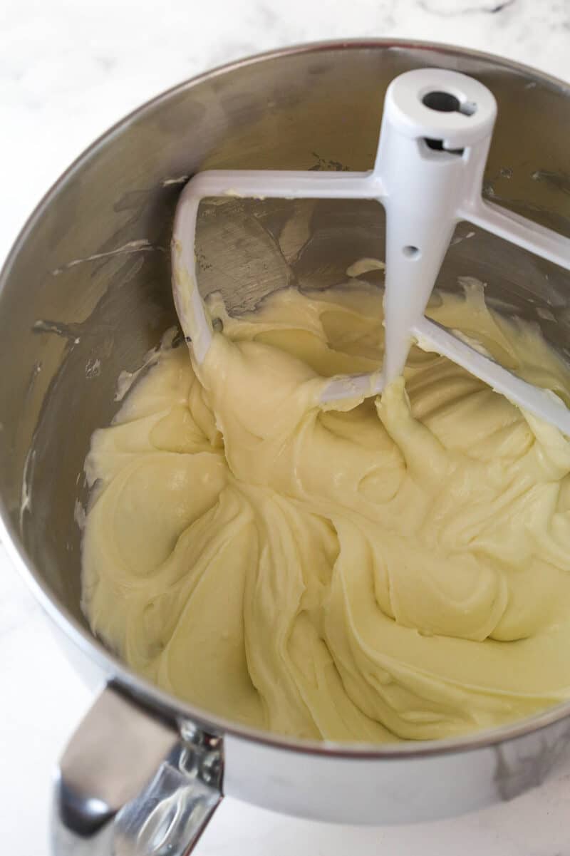 Mixing sour cream into cheesecake filling.