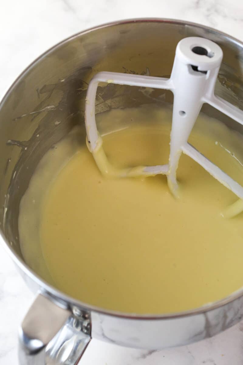 Mixing eggs into cheesecake filling.