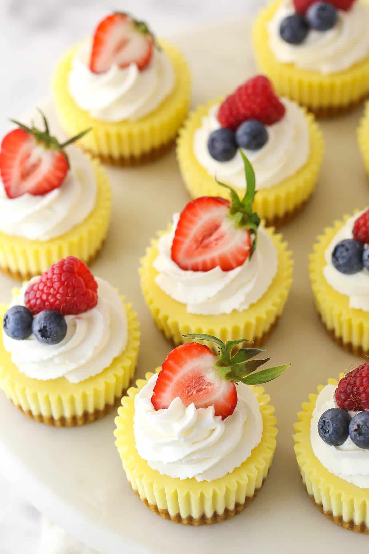 Overhead image of mini cheesecakes topped with fresh fruit.
