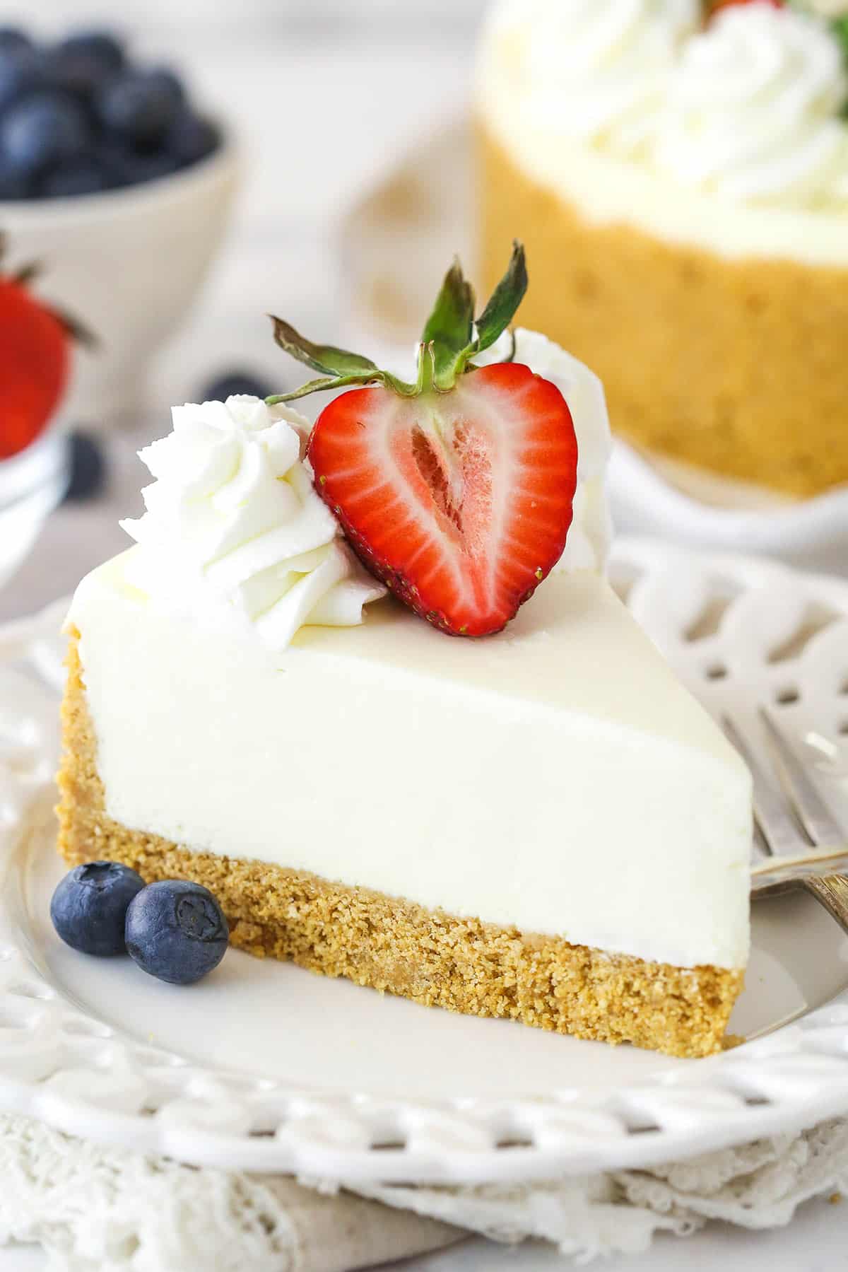 A slice of no bake cheesecake on a plate topped with fresh fruit.