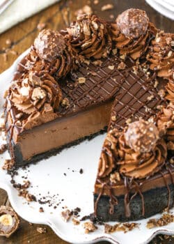 Nutella Cheesecake with a slice removed on a white cake stand