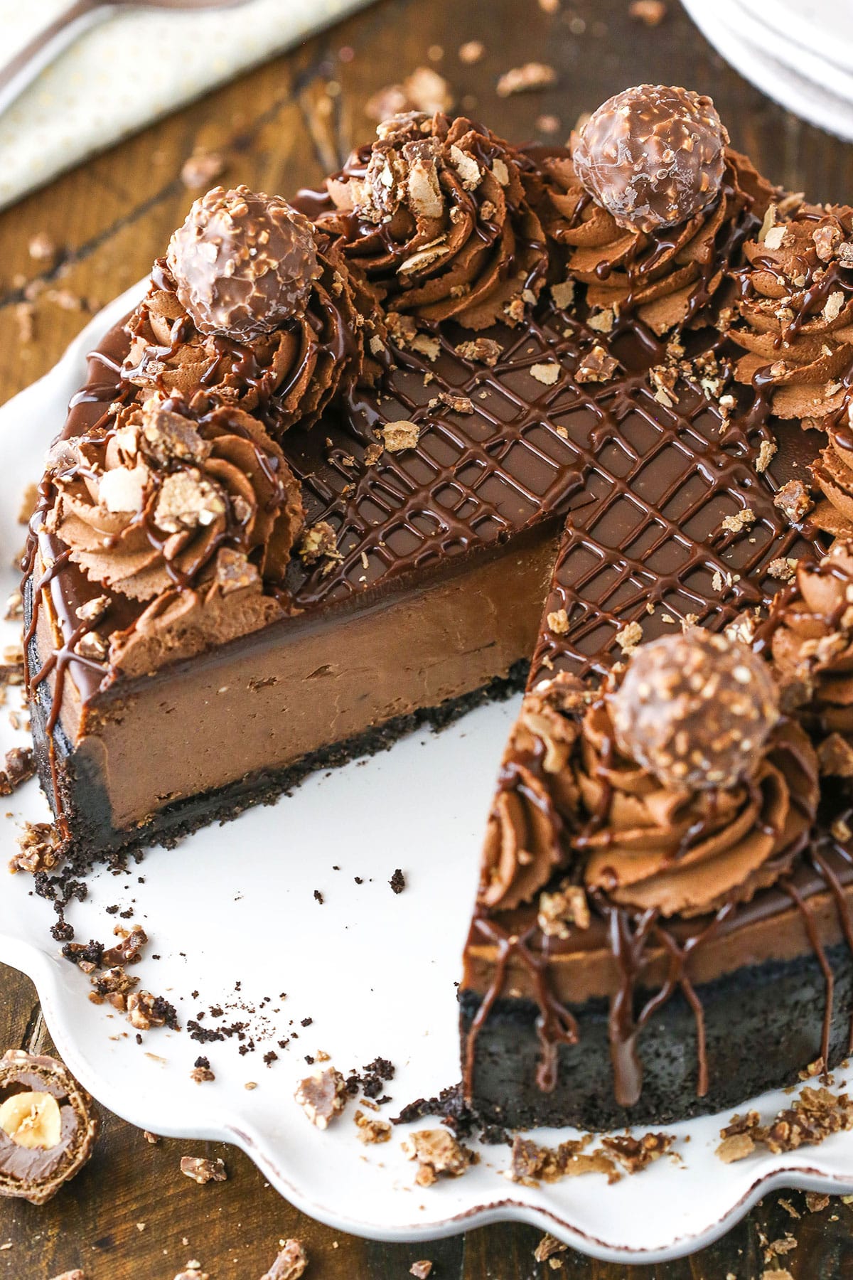 Nutella Cheesecake with a slice removed on a white cake stand