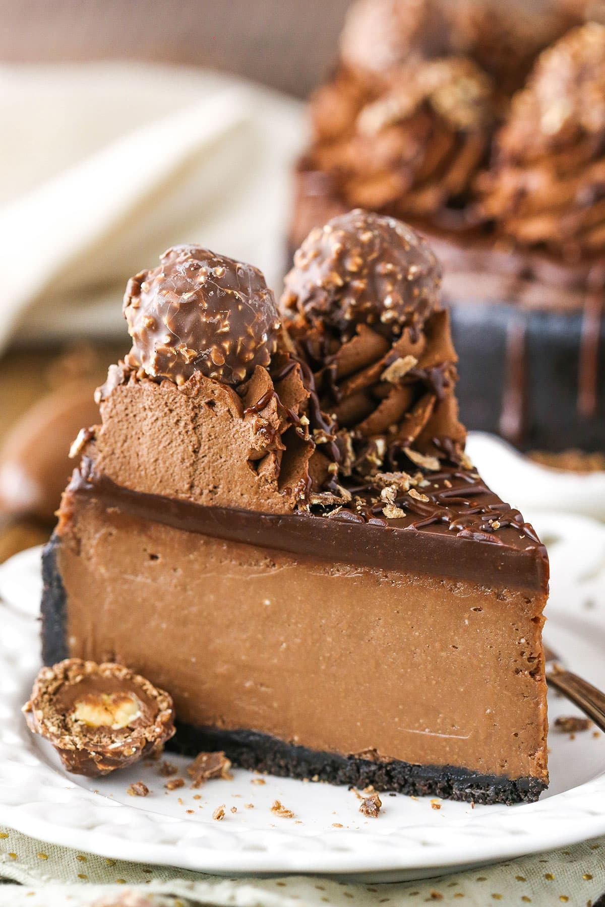 A slice of Nutella Cheesecake next to a fork on a white plate