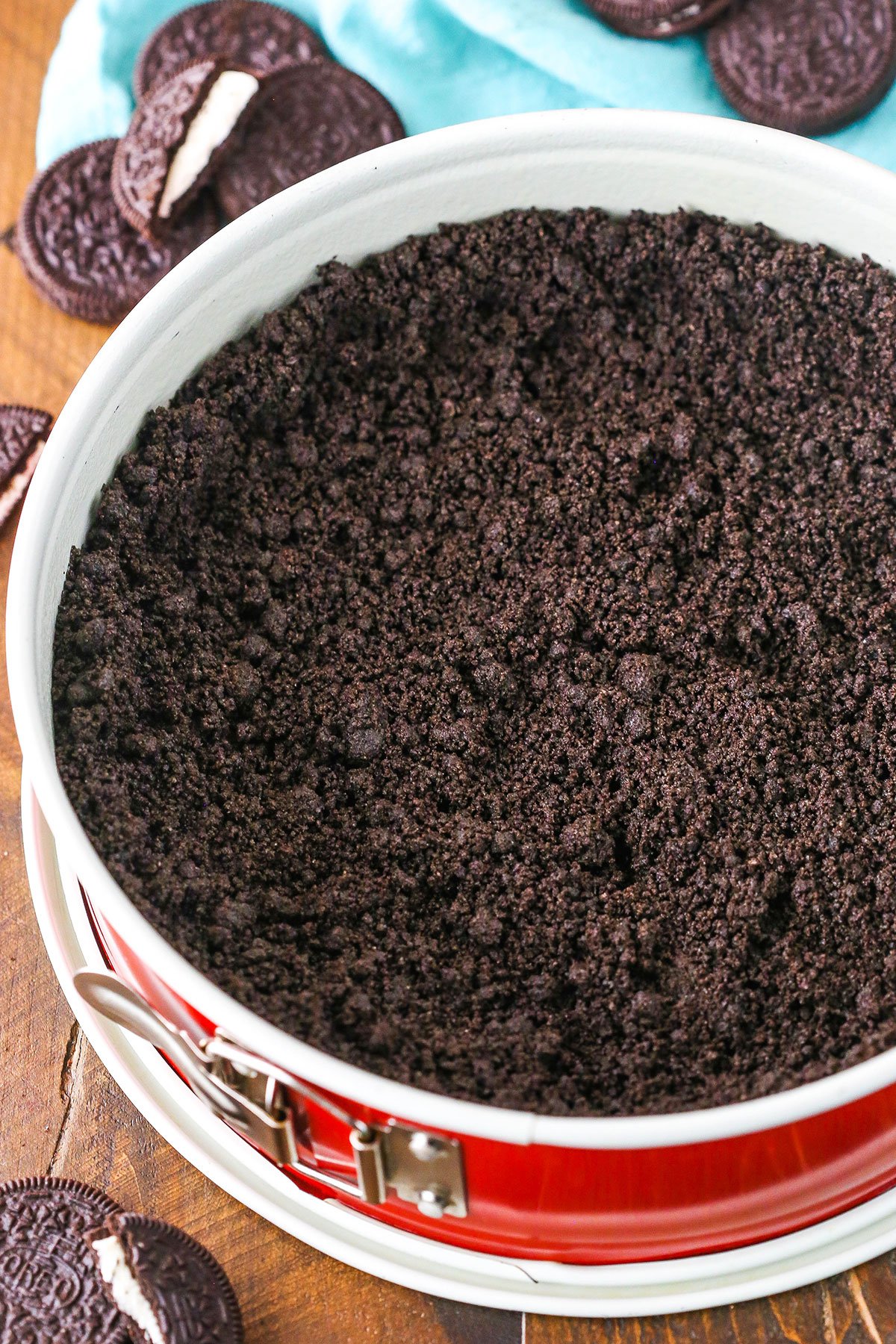 A step in making Oreo Cookie Crust showing the crust mixture in a springform pan