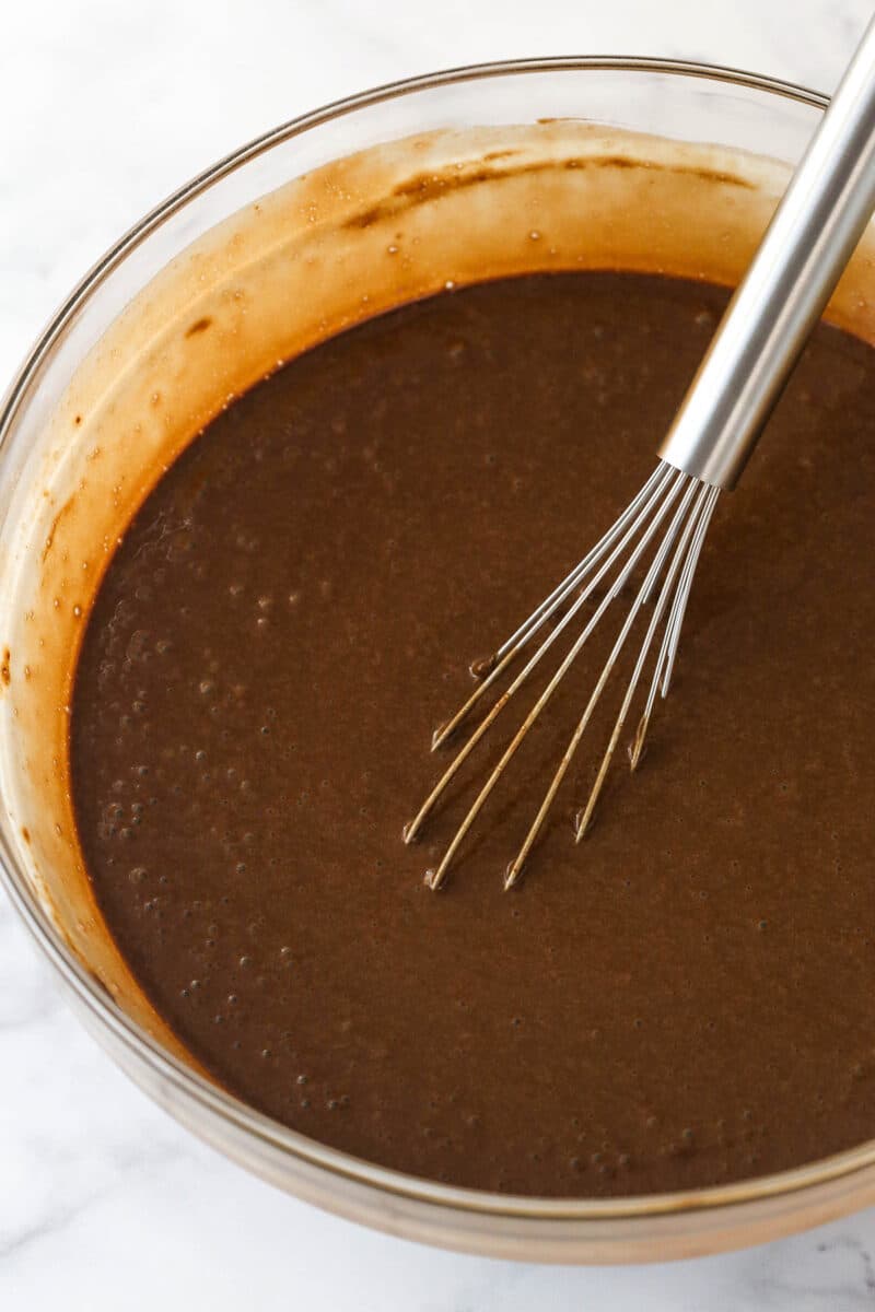 Whisking hot water into chocolate cake batter.