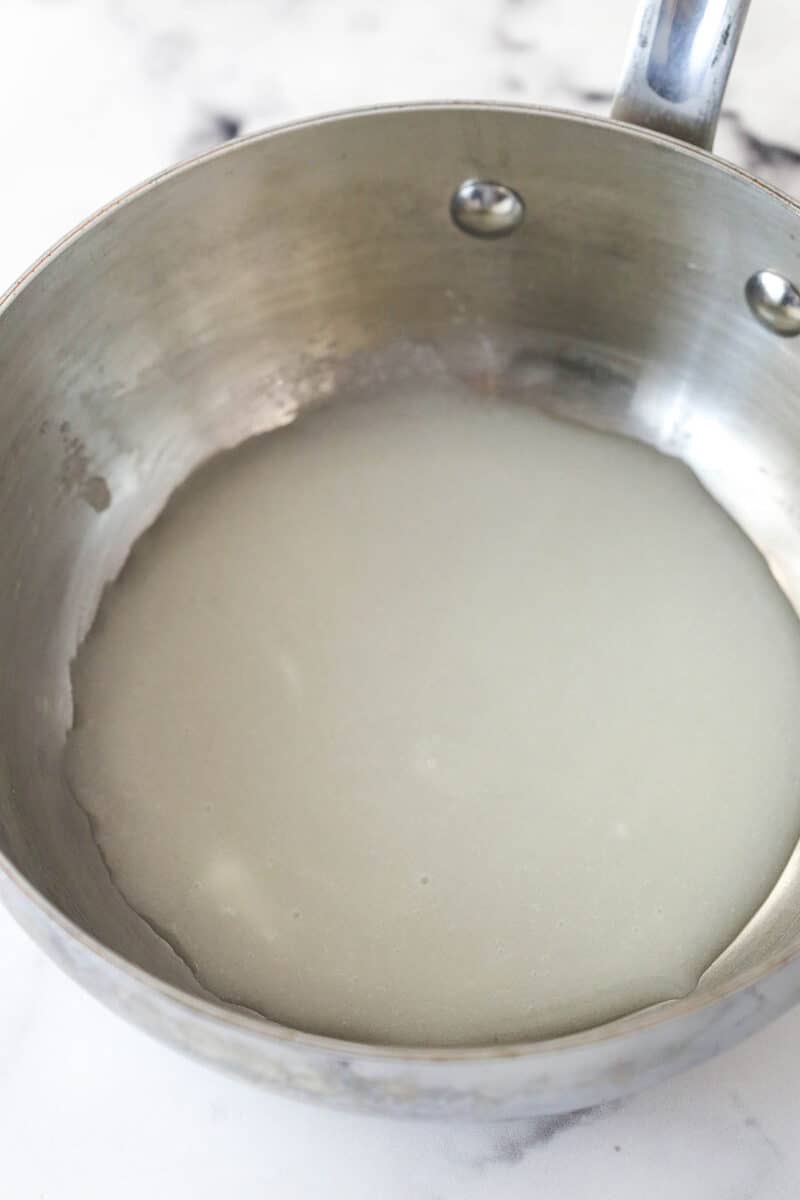 Melting sugar in a pot with cornstarch and water.