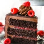 A slice of chocolate raspberry cake on a plate with a fork.