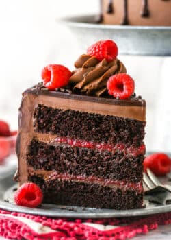 A slice of chocolate raspberry cake on a plate with a fork.