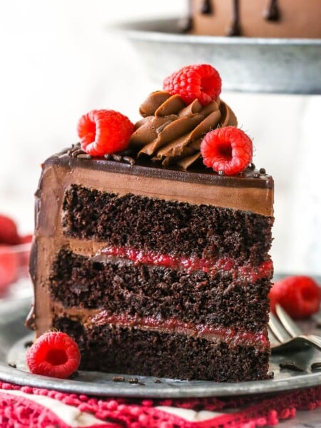 A slice of chocolate raspberry cake on a plate with a fork.