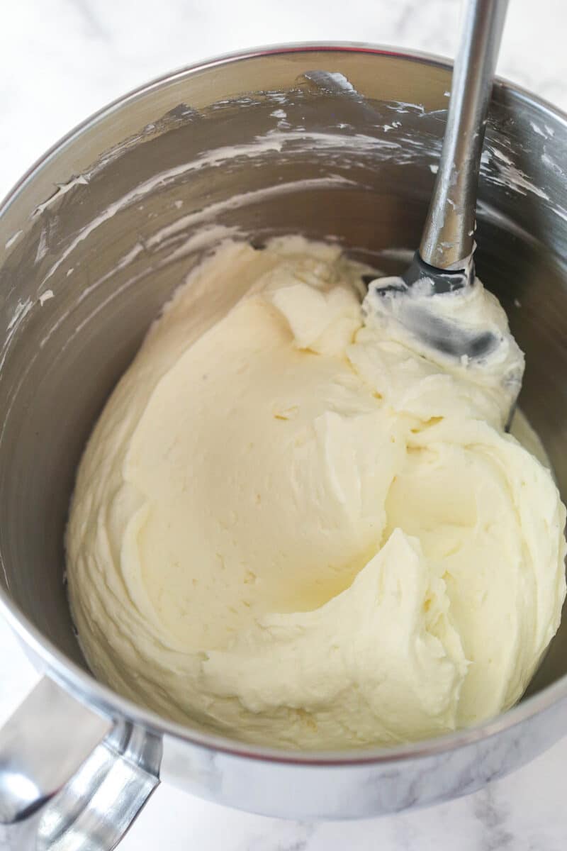Folding whipped cream into cream cheese mixture for no-bake cheesecake filling.