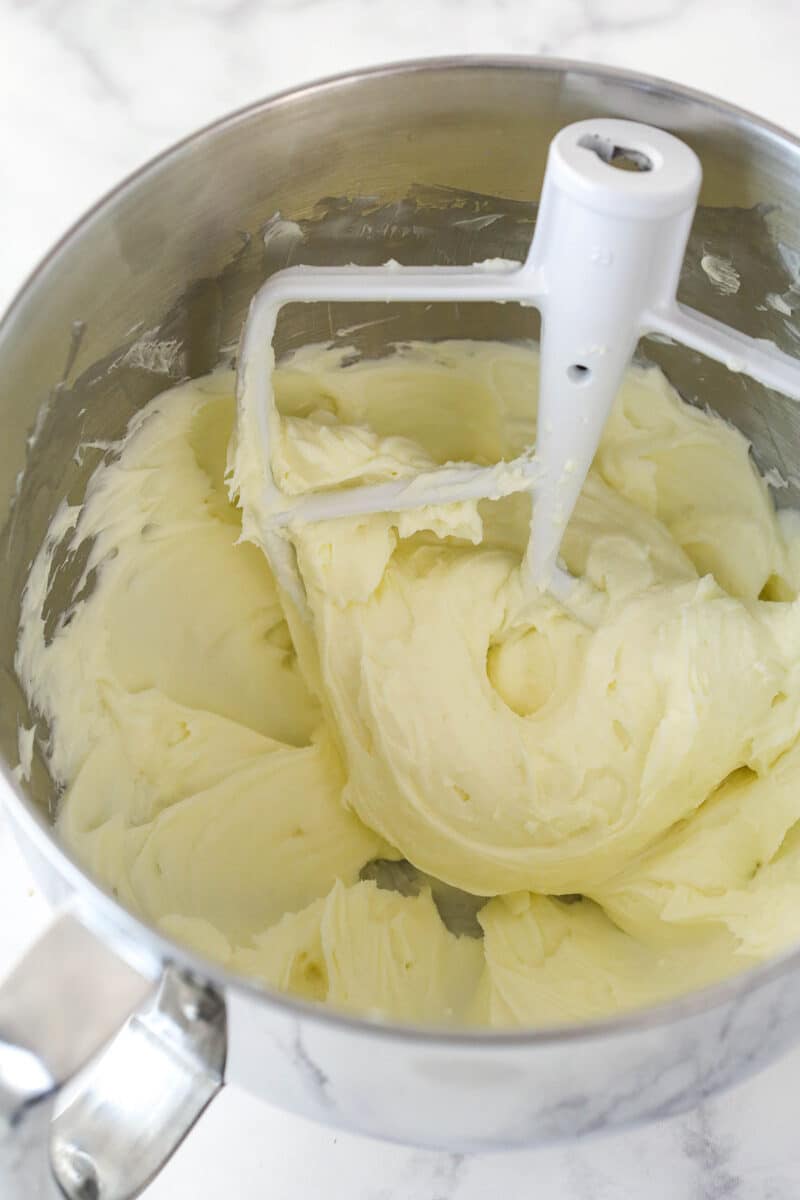 Beating together cream cheese and sugar.