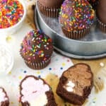 Overhead view of Ultimate Ice Cream Chocolate Cupcakes cut in half and more Ultimate Ice Cream Chocolate Cupcakes in a gray pan