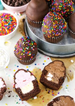 Overhead view of Ultimate Ice Cream Chocolate Cupcakes cut in half and more Ultimate Ice Cream Chocolate Cupcakes in a gray pan