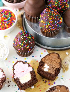 Overhead view of Ultimate Ice Cream Chocolate Cupcakes cut in half and more Ultimate Ice Cream Chocolate Cupcakes in a gray pan