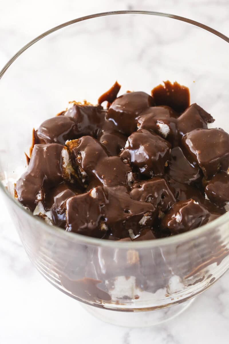 Pouring Nutella ganache over squares of espresso-soaked cubes of angel food cake.