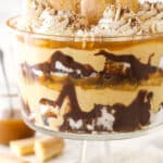 Tiramisu trifle with lady fingers and a jar of caramel sauce in the background.