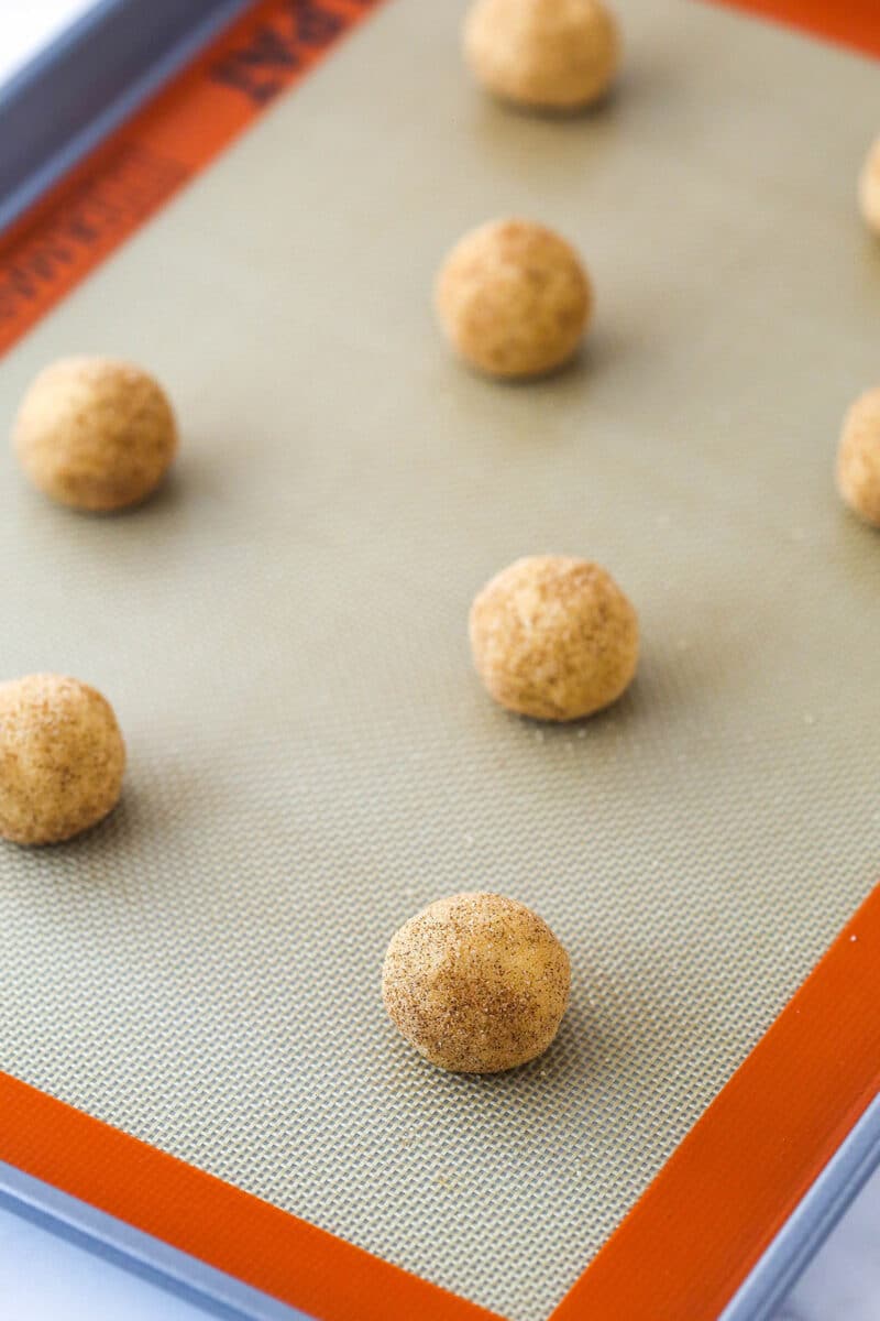Snickerdoodle dough balls on a baking sheet ready to be baked.