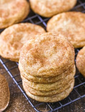 A stack of snickerdoodles on a wire rack.