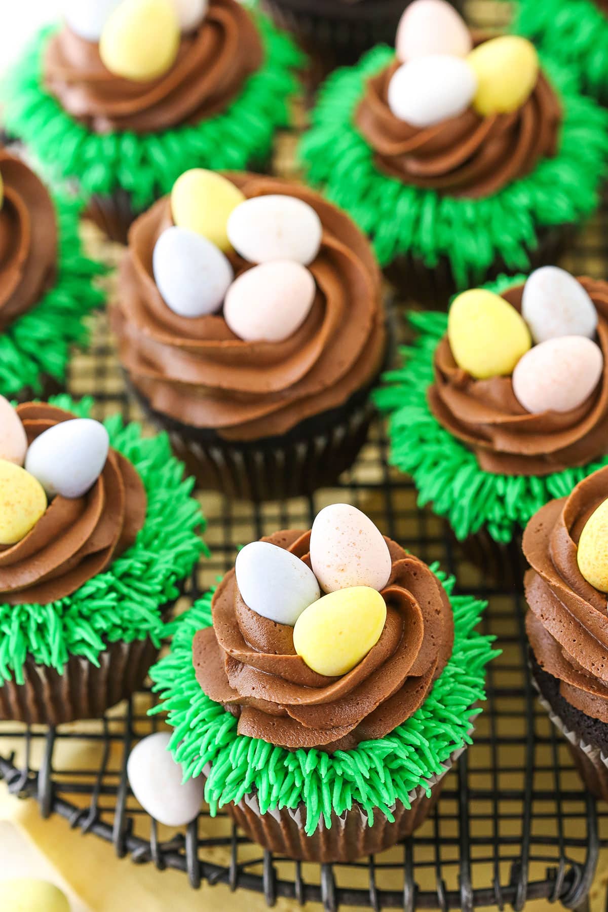 Overhead view of Easter Egg Chocolate Cupcakes on a gray wire cupcake stand