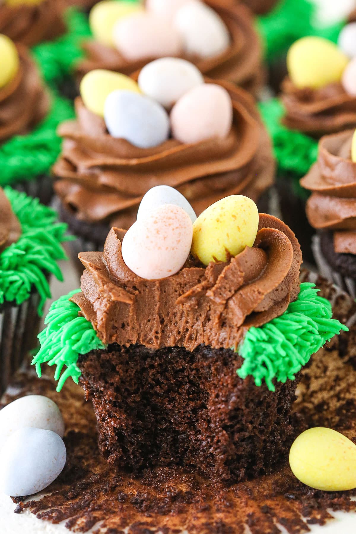 An Easter Egg Chocolate Cupcake with a bite removed and surrounded by more Easter Egg Chocolate Cupcakes