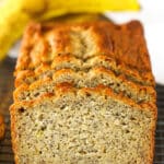 Side view of three Banana Bread slices leaning against the remaining banana bread loaf on a cooling rack