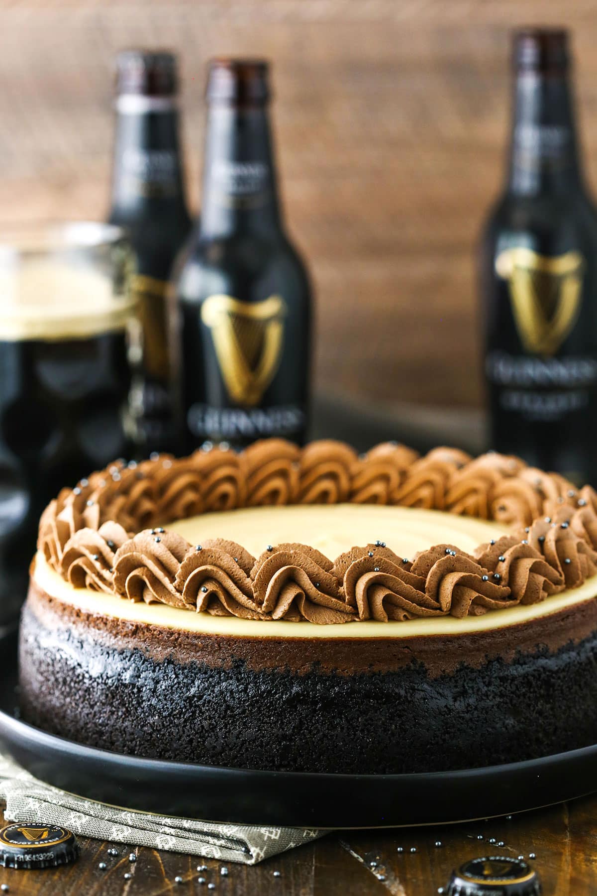 Side view of a full Guinness Chocolate Cheesecake with Guinness beer in the background