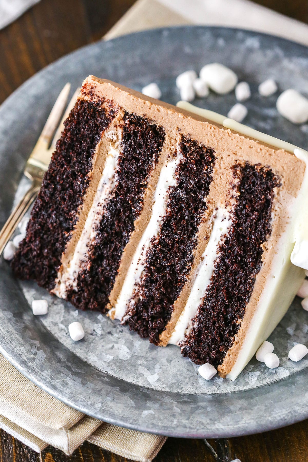 A slice of Hot Chocolate Cake next to a silver fork on a gray plate