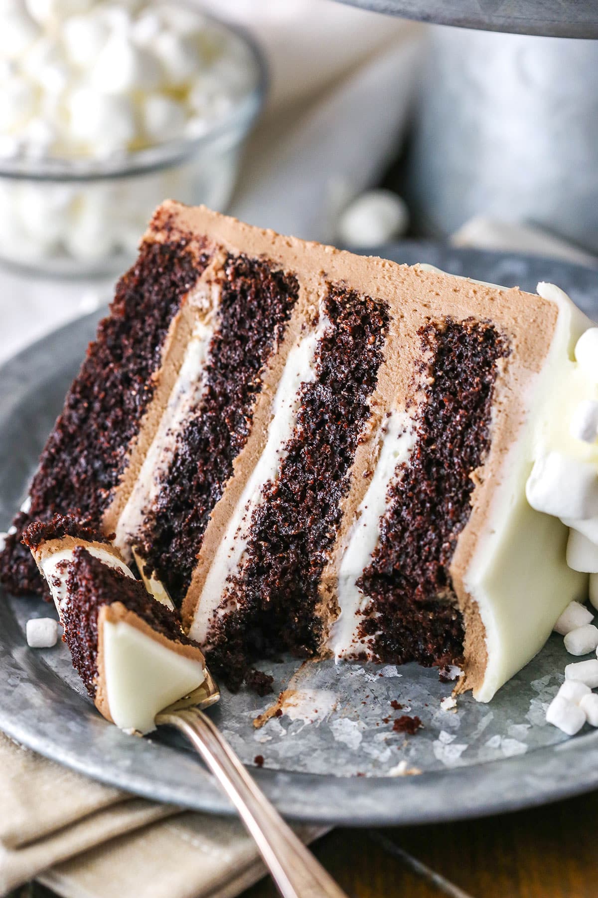 A slice of Hot Chocolate Cake with a bite removed next to a silver fork on a gray plate