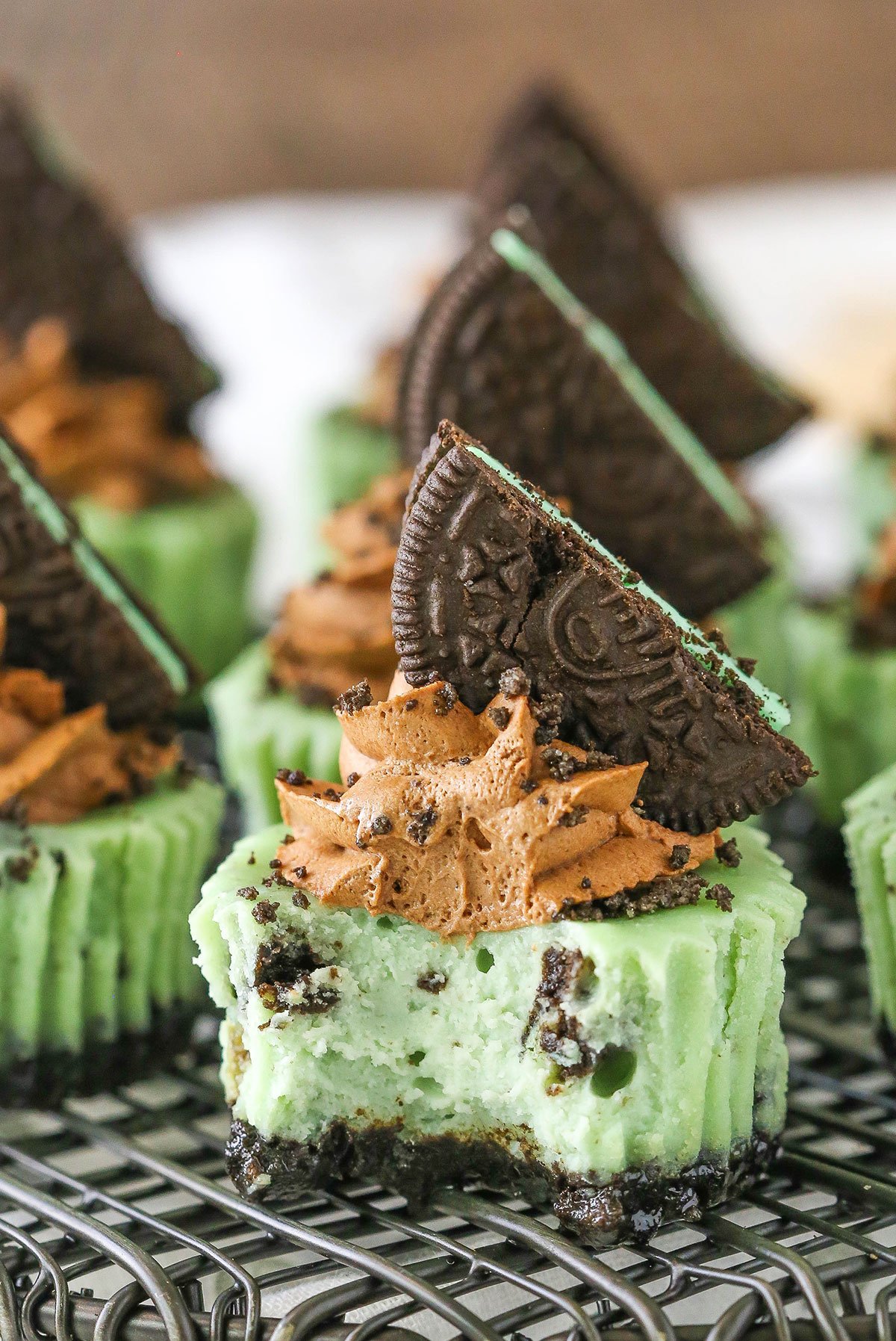 A Mini Mint Chocolate Oreo Cheesecake with a bite removed on a gray metal stand