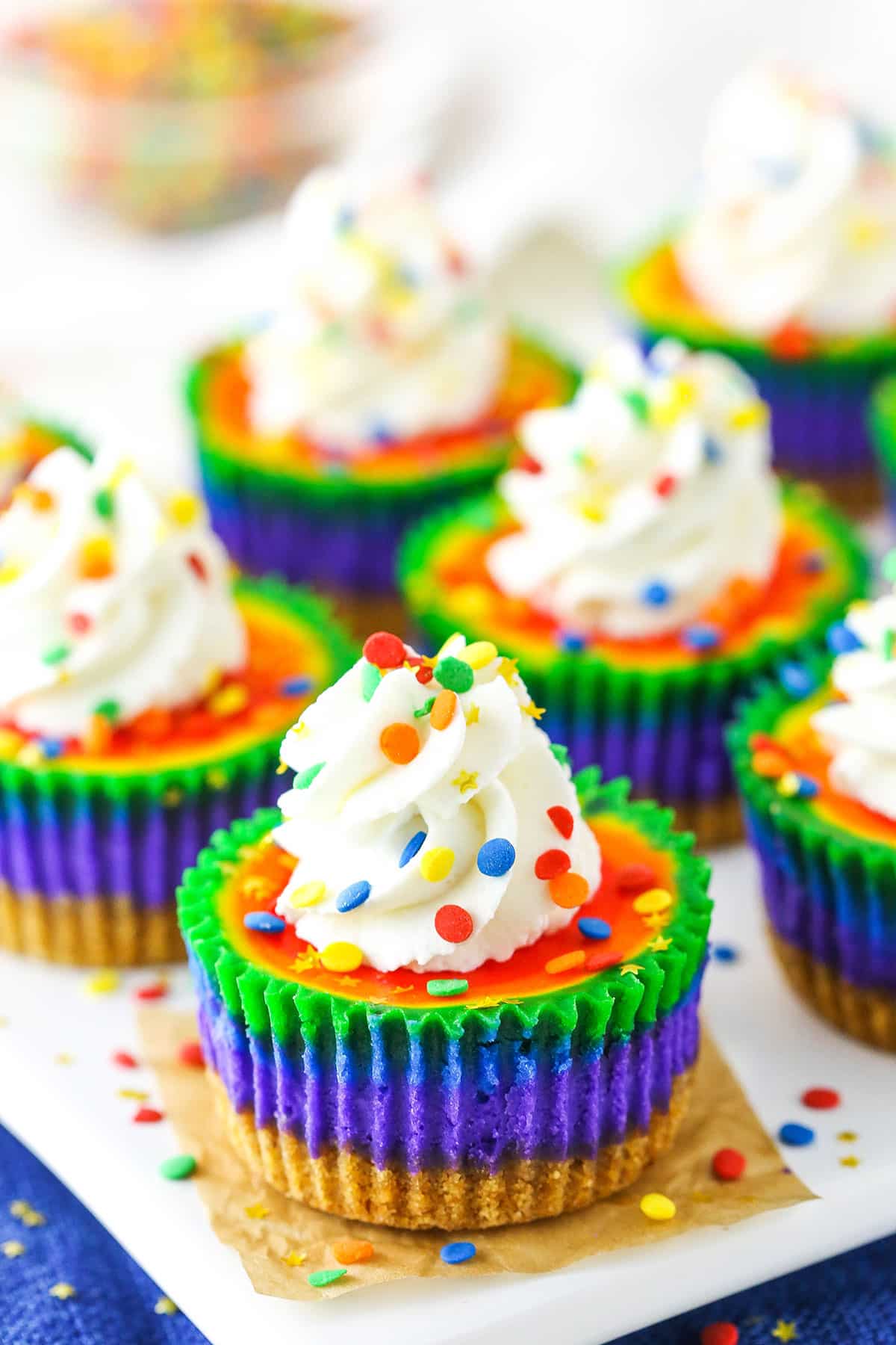 Mini Rainbow Cheesecakes on a white serving tray