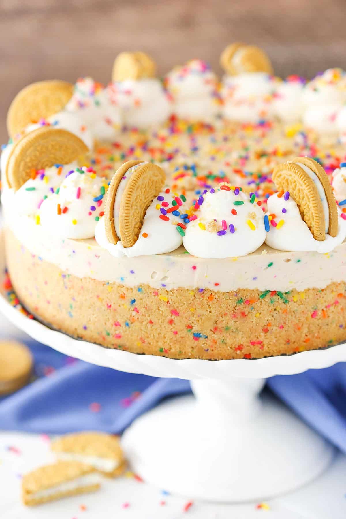 No-Bake Funfetti Oreo Birthday Cake Cheesecake on a white cake stand