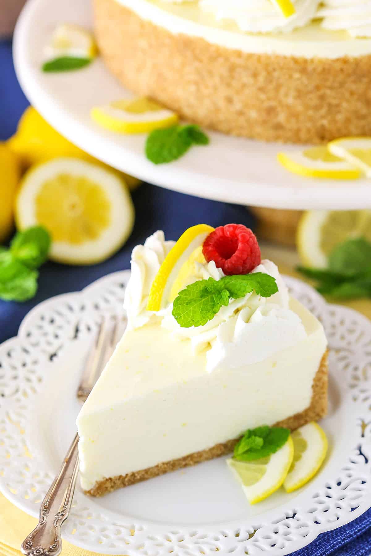 A slice of No Bake Lemon Cheesecake next to a silver fork on a white plate