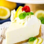 A slice of No Bake Lemon Cheesecake next to a silver fork on a white plate