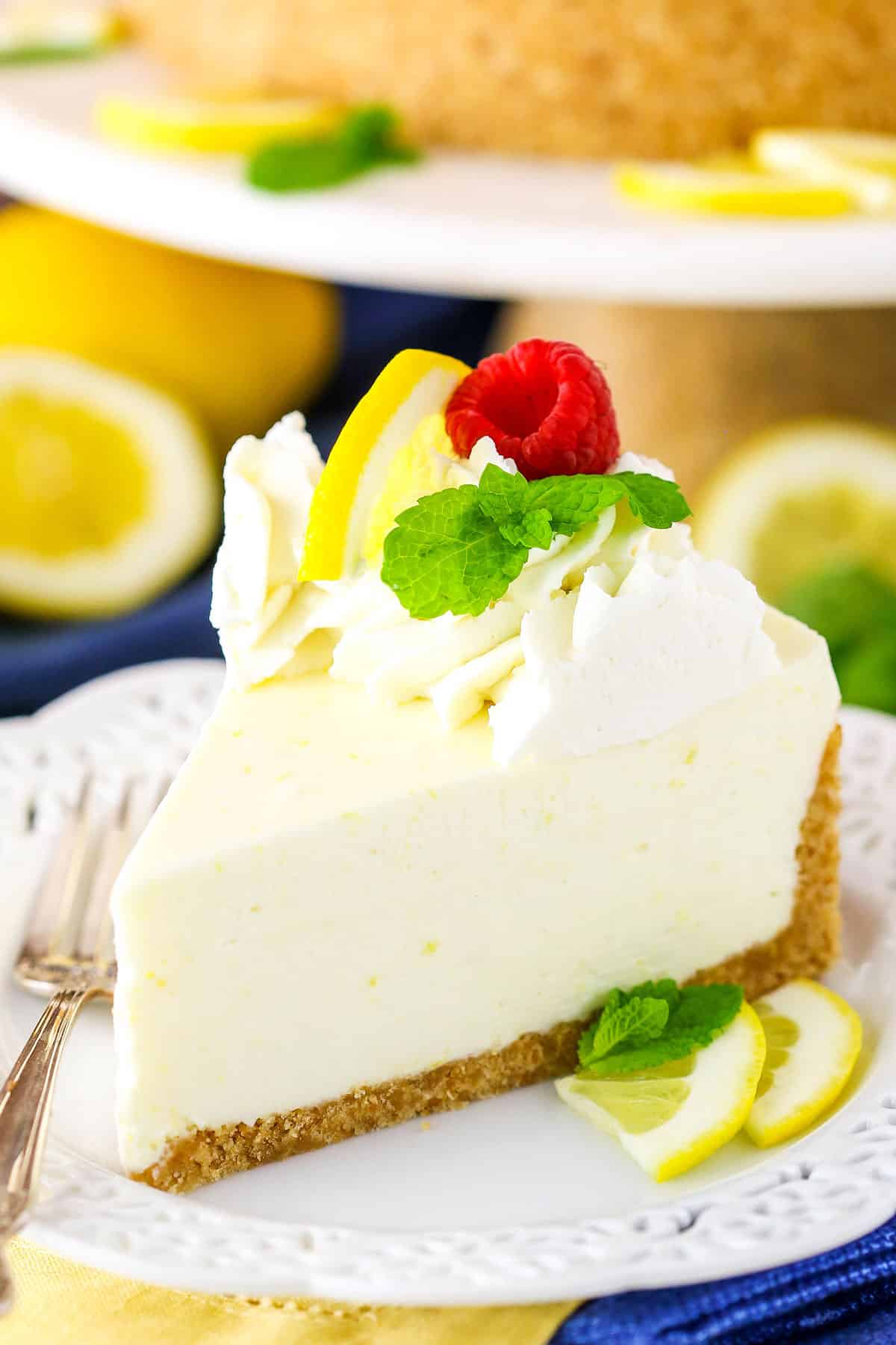 A slice of No Bake Lemon Cheesecake next to a silver fork on a white plate