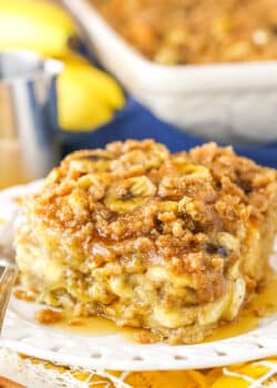 A square serving of Overnight Baked Banana French Toast Casserole next to a silver fork on a white plate