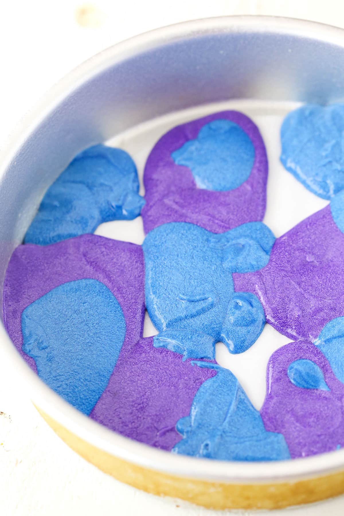 A step in making Rainbow Swirl Cake showing the layering of the cake batter to create the swirl effect