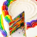 A Rainbow Swirl Cake with a slice removed showing the colorful internal layers