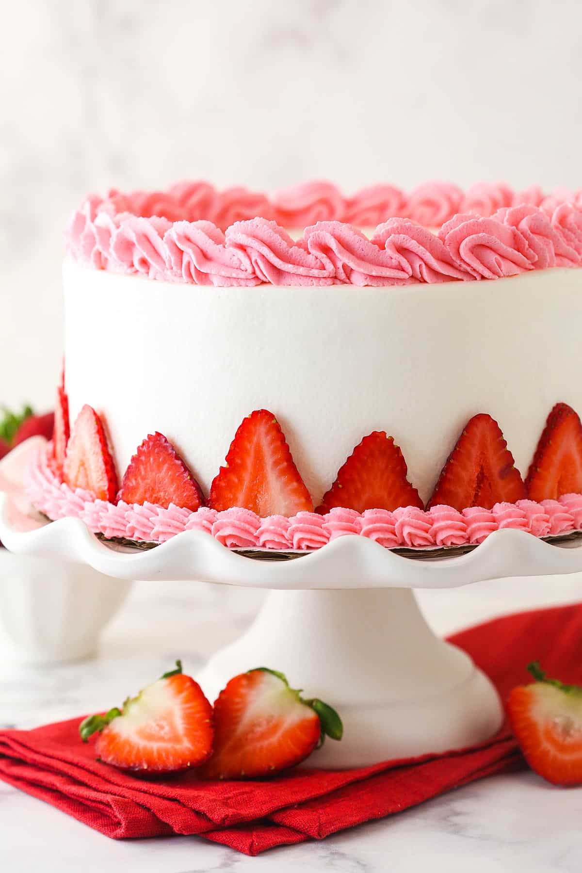 Strawberry ice cream cake on a cake stand.
