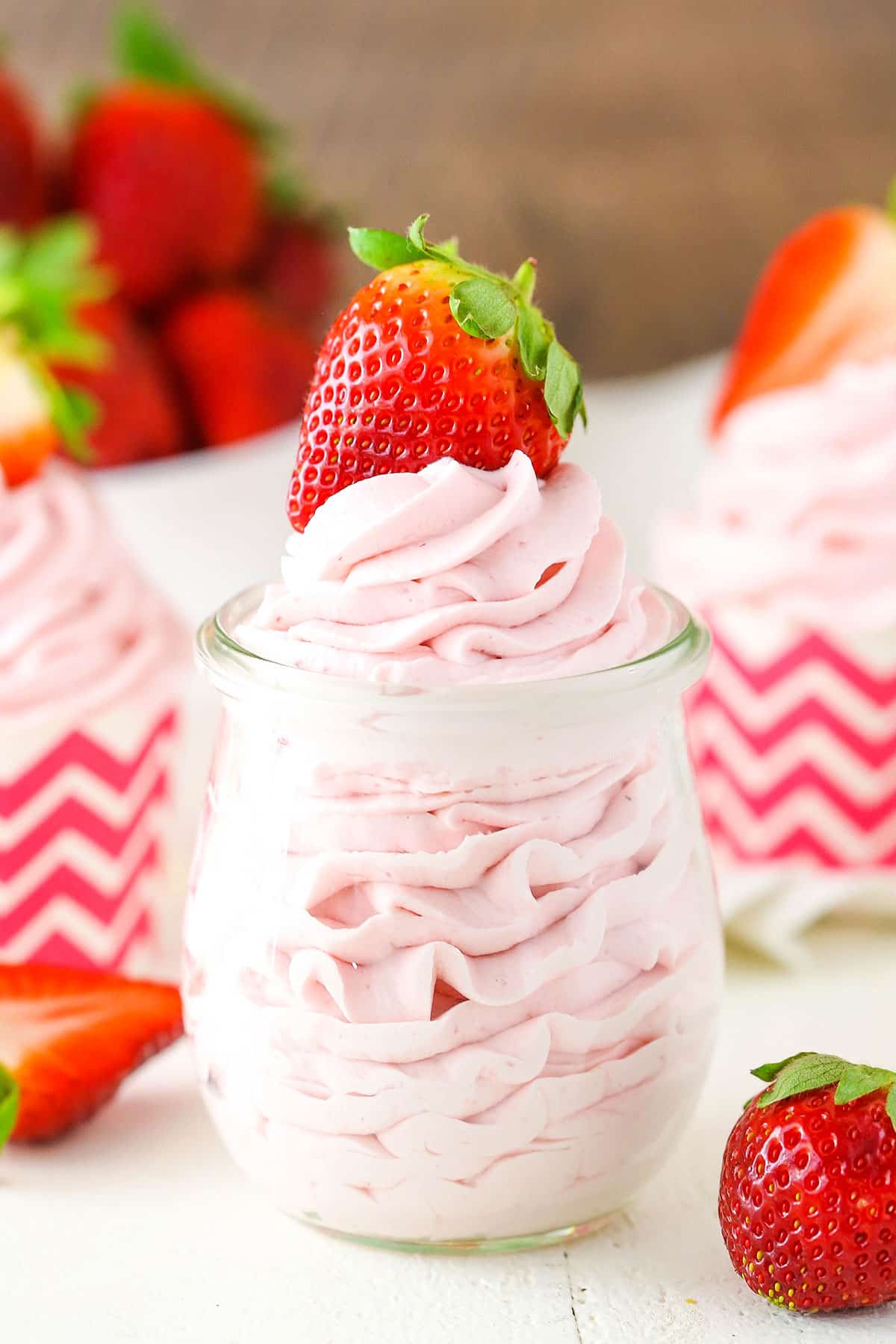 Homemade Strawberry Whipped Cream piped into a clear glass jar