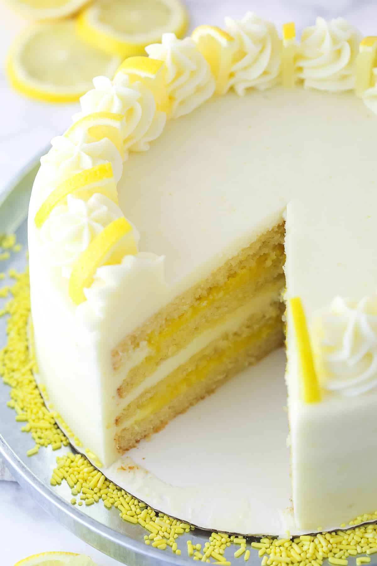 Overhead image of lemon curd cake with a slice taken out of it.